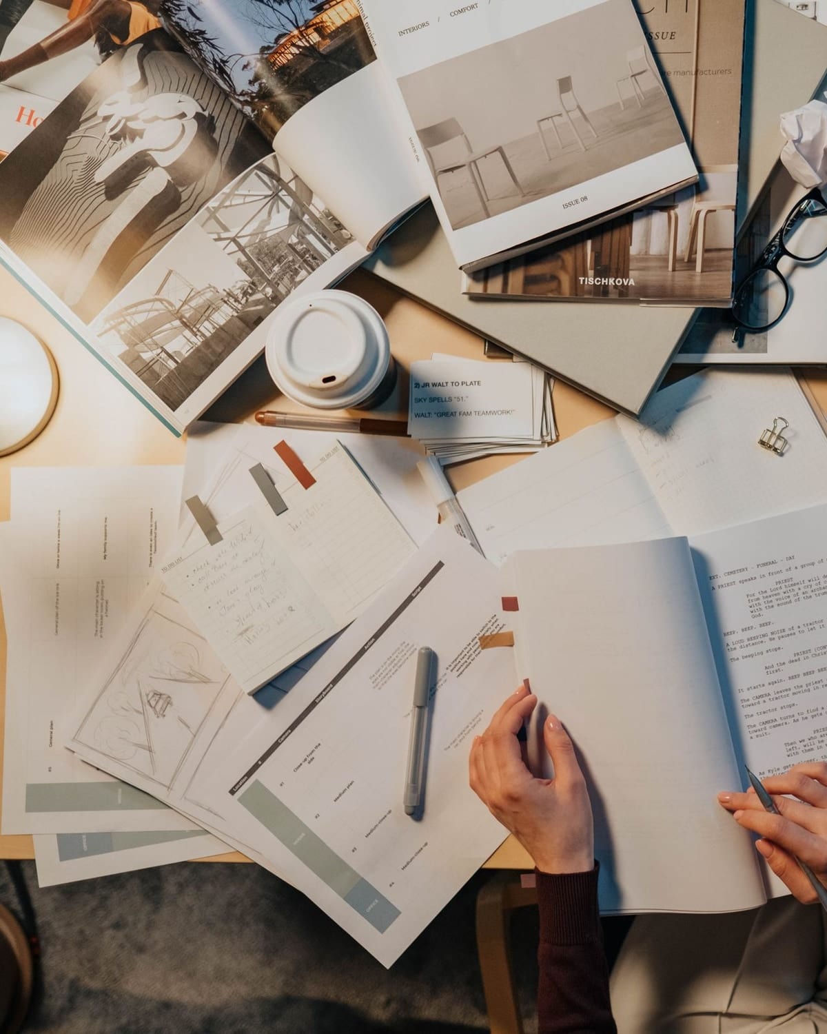 Hands writing over a page of notes at a desk