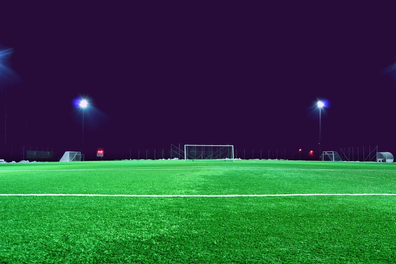 A floodlit football pitch at night